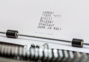 Close up of paper on a typewriter with the text 
DANKE!
THANK YOU!
MERCI!
GRAZI!
GRACIAS!
DANK JE WEL!